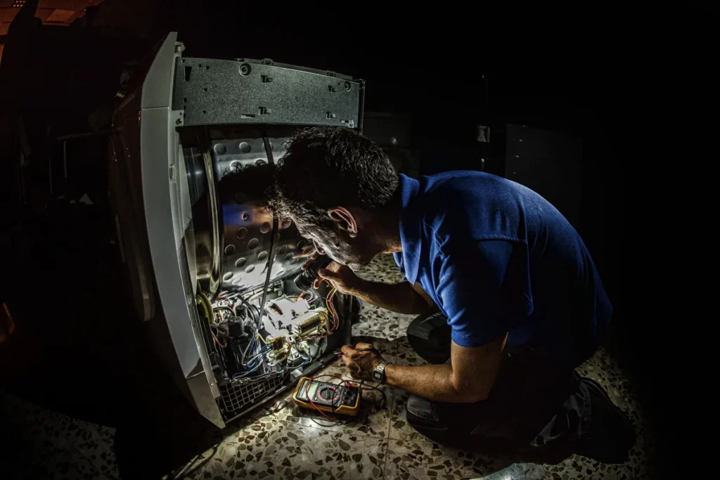 Fenixlight. Trabajador de mantenimiento iluminando un mecanismo eléctrico.