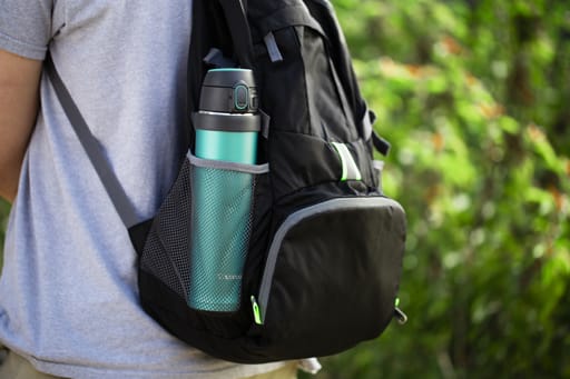 Chico con mochila negra y botella Zojirushi verde al lado