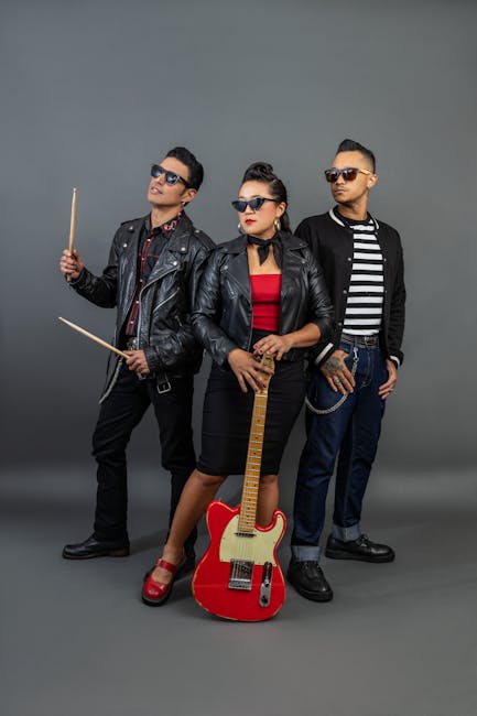 Moda Urbana Fashionable band members posing with musical instruments in studio setting.