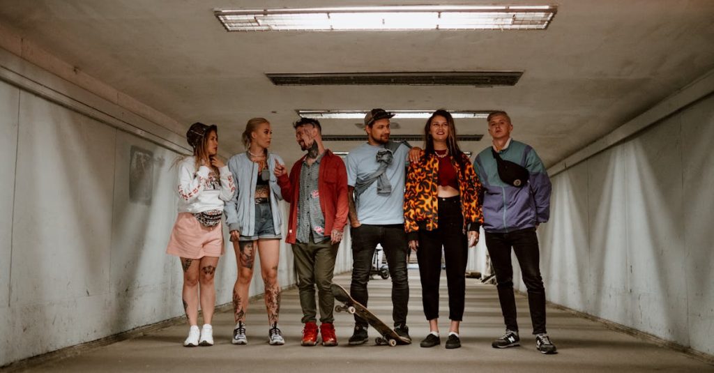 Moda Urbana Six youthful friends in trendy clothing standing in a modern underground walkway.