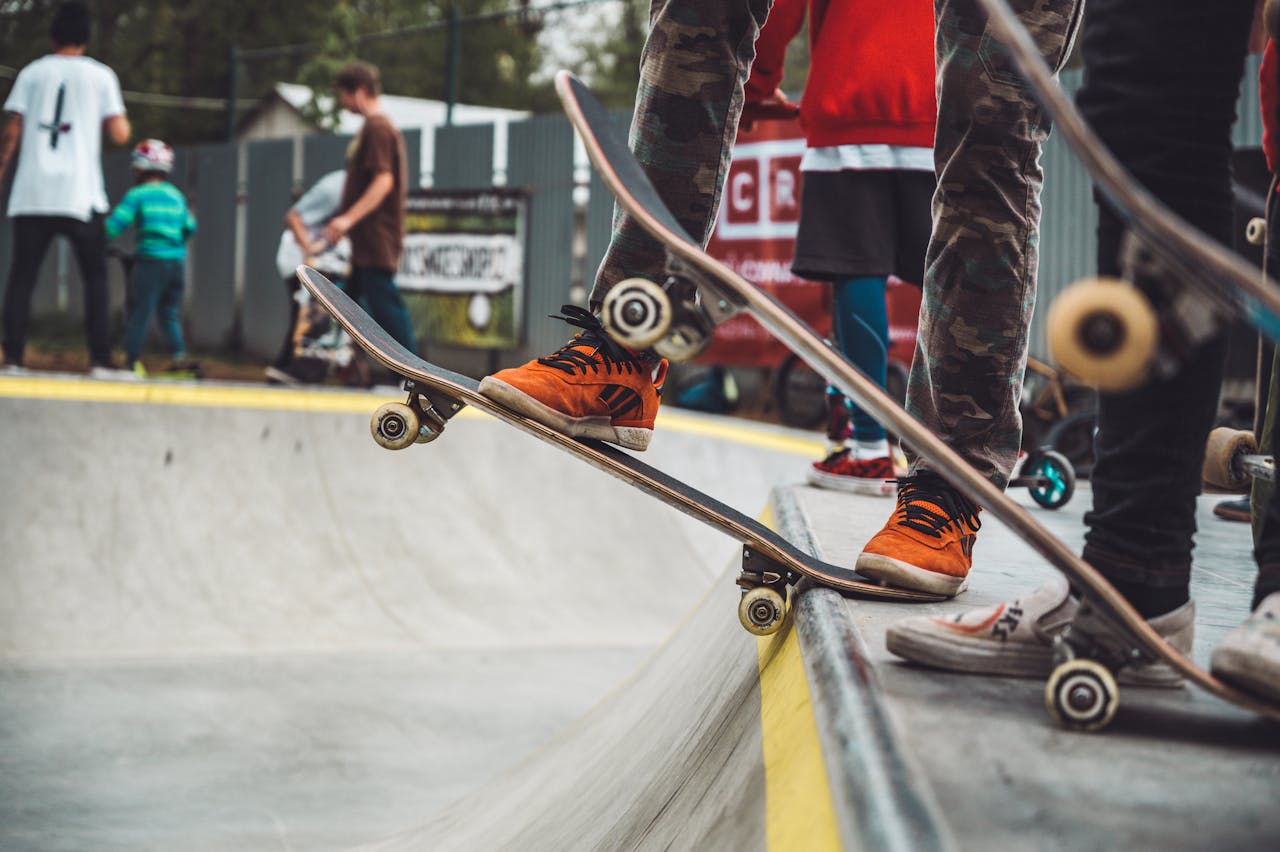 Kids and teens skateboarding at a lively outdoor skatepark, showcasing urban street culture and style.